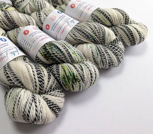 Four skeins of yarn with labels on a white background