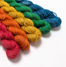 Load image into Gallery viewer, Colorful yarn skeins in red, orange, yellow, green, and blue on a white background
