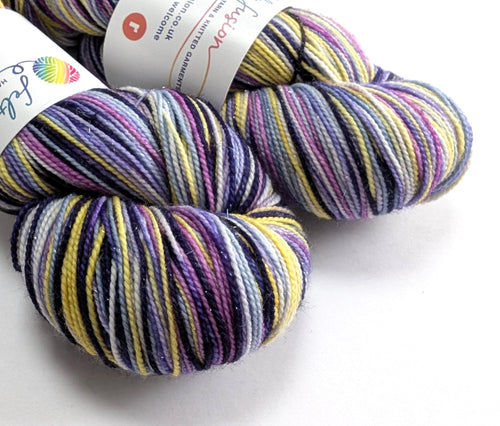 Two skeins of multicolored yarn with labels on a white background