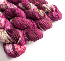 Load image into Gallery viewer, Skeins of pink and purple yarn with speckles on a white background
