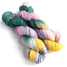 Load image into Gallery viewer, Two skeins of yarn on a white background.  The yarn has been dyed in dark green, yellow, lilac, pink and has black splashes.
