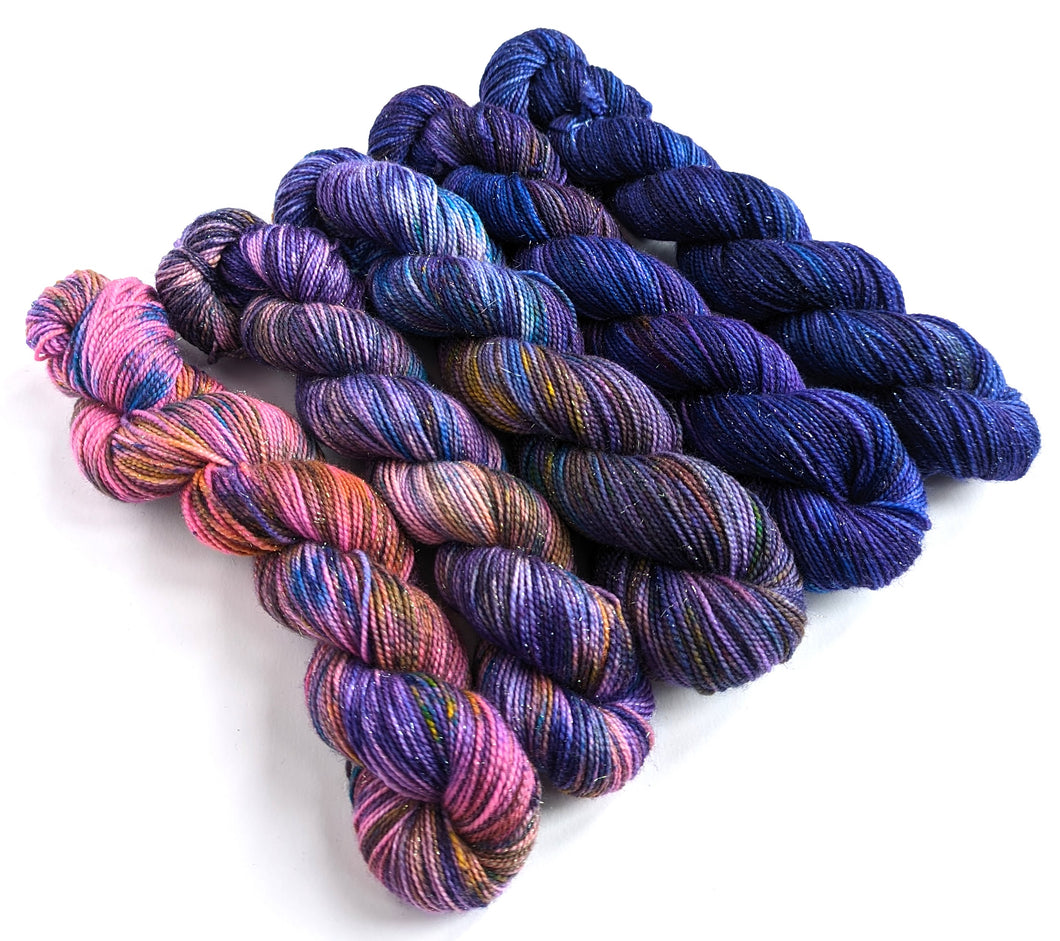 Pink-purple gradient yarn set on a superwash merino/nylon/sparkle sock yarn.